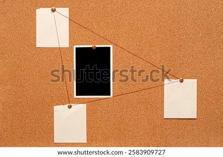 Blank paper notes and an empty photo are pinned to a cork board. The concept of detective investigation.