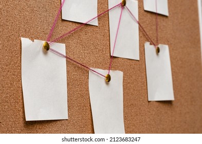 Blank Paper Notes Are Pinned To A Cork Board. The Concept Of Detective Investigation. Copy Space.