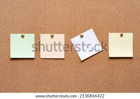 Blank paper notes are pinned to a cork board. Copy space.