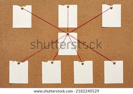 Blank paper notes are pinned to a cork board. The concept of detective investigation. Copy space.