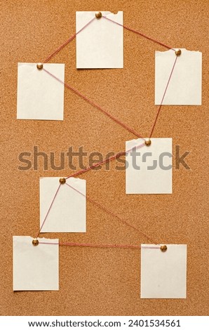 Blank paper notes are pinned to a cork board. The concept of detective investigation. Copy space.