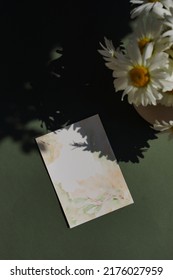 Blank Paper Sheet Card Watercolor Mockup,bouquet Of Daisies Flowers And Sunlight Shadow Top View On Green Background.Copy Space. Template, Invitation, Greeting Card, Wedding Stationary Scene