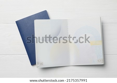 Blank passports on white wooden table, flat lay