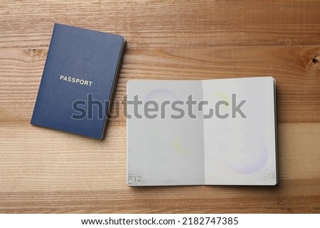 Blank passports on wooden table, flat lay