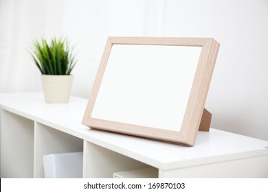 Blank Photo Frame With Copy Space On White Bookshelf At Home