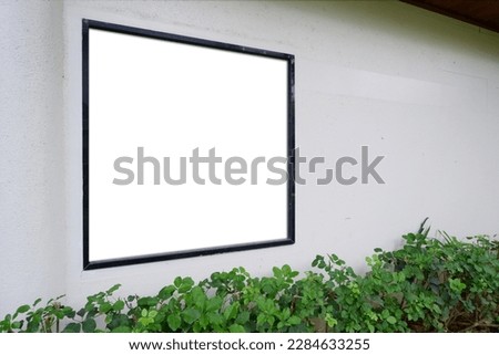 Blank photo frame mock up on white wall. White wall and green leaves. outdoor exhibition mock up.