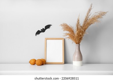 Blank Photo Frame, Vase With Pampas Grass And Fruits On Mantelpiece Near Light Wall