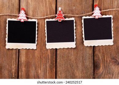 Blank Photo Frames And Christmas Decor On Rope, On Wooden Background