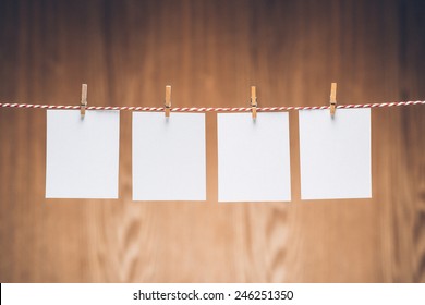 Blank photo frames hanging on the clothesline . Isolated on wooden background. Vintage style.  - Powered by Shutterstock