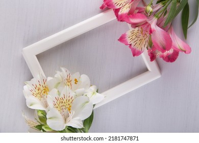 Blank Photoframe With Bright Alstroemeria Lilly Exotic Flowers On White Background. Flat Lay Table Top View With Floral Composition. Top View, Copy Space For Text