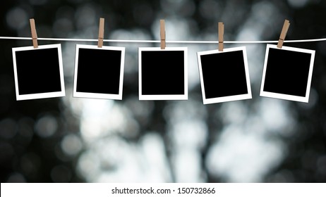 Blank photographs hanging on a clothesline against a Bokeh lights background