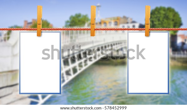 Blank photos hanging on clothesline\
with Half Penny Bridge on background (Dublin -\
Ireland)