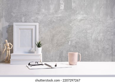 Blank Picture Frame, Books, Coffee Cup And Small Potted Plant On White Table. Copy Space For Text.