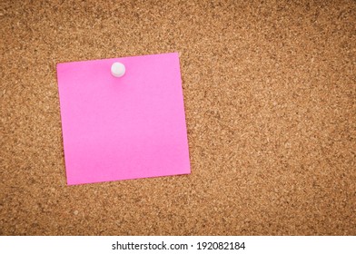 Blank Pink Sticky Note On Corkboard Background