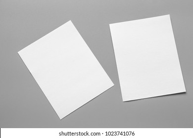 Leeres Portrait-Mockup-Papier. Broschüre einzeln auf grauem, veränderlichem Hintergrund / weißes Papier einzeln auf Grau