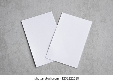 Blank portrait mock-up paper. brochure magazine isolated on gray, changeable background / white paper isolated on gray cement backdrop.