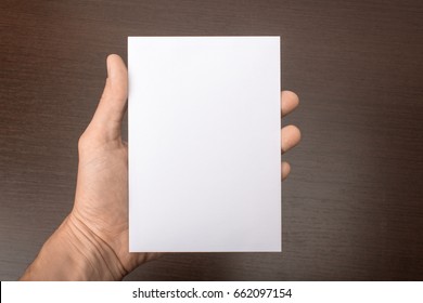 Blank Postcard In Hand On A Gray Background. Leaflet A6 Mockup