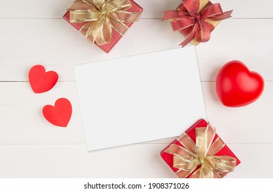 Blank Postcard Size A5 And Letter And Gift Box And Heart Shape On Wooden Table, Mockup Greeting Card And Template, Decoration With Romantic, Celebration Valentine Day And Holiday Concept.