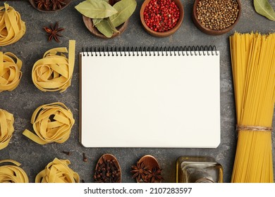 Blank Recipe Book, Spices And Raw Pasta On Dark Grey Table, Flat Lay. Space For Text