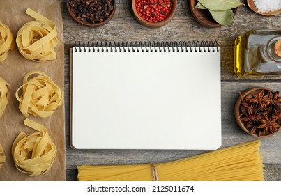 Blank Recipe Book, Spices And Raw Pasta On Wooden Table, Flat Lay. Space For Text