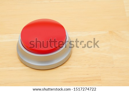 A blank red push button on a wooden desk with copy-space for your message