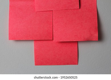 Blank Red Sheets Of Paper For Notes And Writing On The White Wall Close Up