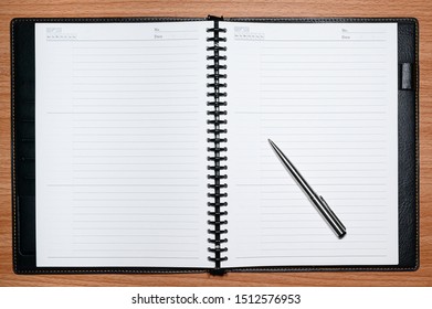 Blank Refillable Line Paper Notebook With A Stainless Steel Ball Pen On A Beech Table