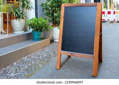 Blank Restaurant Shop Sign Or Menu Board Near The Entrance To Restaurant Or Flower Shop. Cafe Menu On The Street. Blackboard Sign Mockup, Signboard, Freestanding A-frame Blackboard.