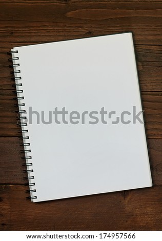 Blank ring bound scrap book on a rustic wooden background with copy space for insertion of your message or design elements.
