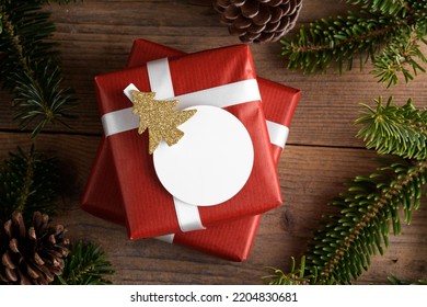 Blank round Christmas gift tag mockup with red present box, product label mockup, with natural fir tree branch, cones and Christmas decoration, Christmas sale concept - Powered by Shutterstock