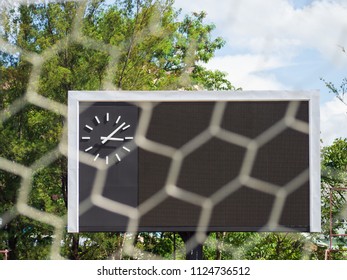 Blank Score Board And Clock With Blurry Goal Net At Football Stadium.Outdoor Sport.