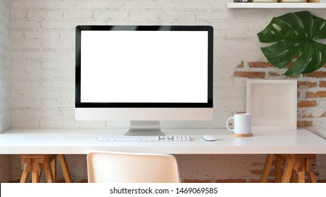 Blank screen desktop computer in minimal office room with decorations and copy space 