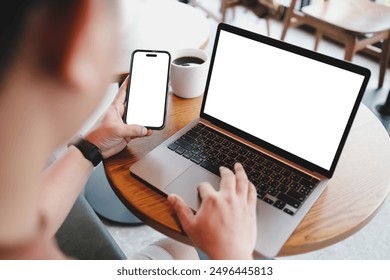 A blank screen for hand typing text,using laptop and mobile phone contact business searching information in workplace on desk at office.