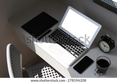 blank screen laptop computer and smart phone and digital tablet and stylus pen is on wooden desk as workplace concept