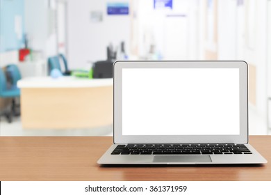 Blank Screen Laptop On Wooden Table With Blur Hospital Background