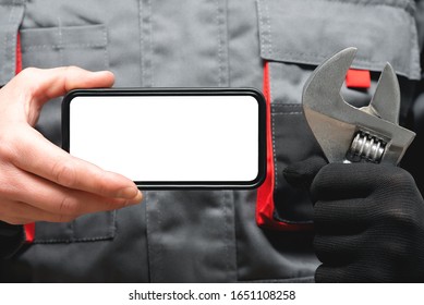 A Blank Screen Mobile Phone With Copy Space And A Adjustable Wrench In Plumber Or Auto Mechanic Hands Close Up.