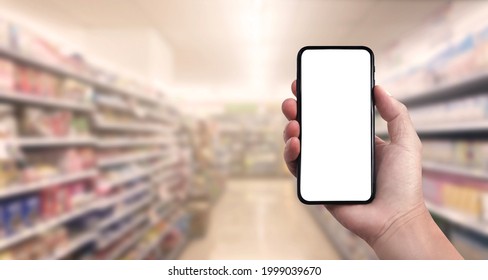 Blank screen of Mobile phone with hand holding phone on Soft blurry Supermarket store background. of free space for your copy and Branding. - Shutterstock ID 1999039670