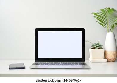 blank screen Modern laptop computer with mouse,Smart phone and Succulent on wood table in office view backgrounds - Powered by Shutterstock