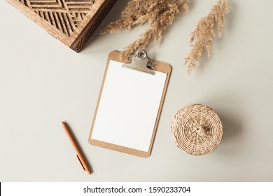 Blank Sheet Clipboard With Empty Copy Space, Pen, Rattan Casket On Neutral Background. Flat Lay, Top View Minimal Business Template For Social Media, Magazine, Blog. Home Office Desk Table Workspace.