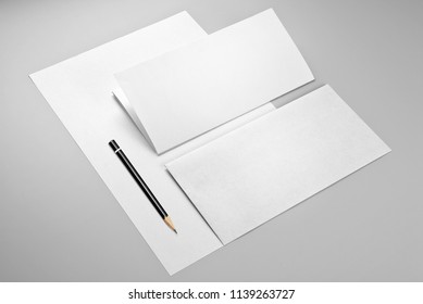 Blank sheet of paper, folded sheet of paper, envelope, and pencil