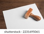 Blank sheet of paper and visa stamp on wooden table