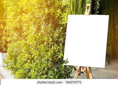 A Blank Sign With Easel Is Standing Beside Trees. Green Background.