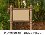Blank signage made of natural wooden poles tied together with rope in a forest.  A blank sign ready to add your own graphic designs sits in a tropical lush forest.