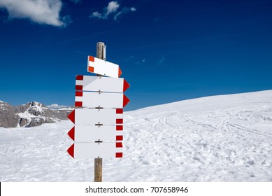 Blank signpost in the snowy mountains with many directions