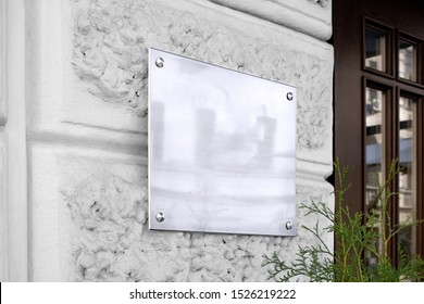 Blank silver glass signboard on textured wall mockup. Empty wal mounted signplate mock up. Clear outdoor plexiglass signage for hotel or store info mokcup template.