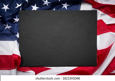 Blank slate board over American flag as a concept for US national celebrations - Powered by Shutterstock