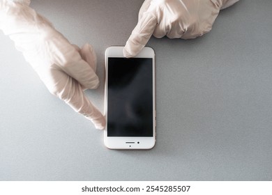 Blank smartphone held in hand in blue protective glove, isolated on white background. Copy space for a text. - Powered by Shutterstock