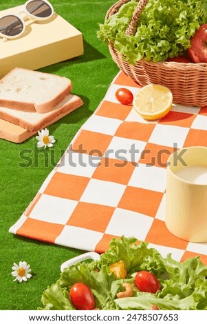 Blank space in a corner of checkered orange carpet spread on green lawn, surrounded by fresh food like vegetable, fruit, sandwich and milk. High angle shot photo with space for showing product