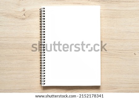 Blank spiral bound notepad mockup template with Kraft Paper cover, isolated on wood background. High resolution.