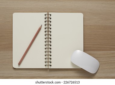 Blank Spiral Note Pad, Computer Mouse And Pencil On Wood Background.